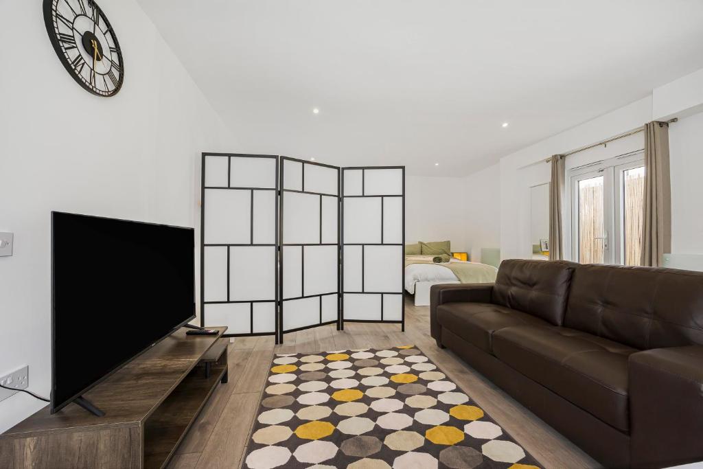 a living room with a couch and a flat screen tv at London Haven at Rutland House in Ilford