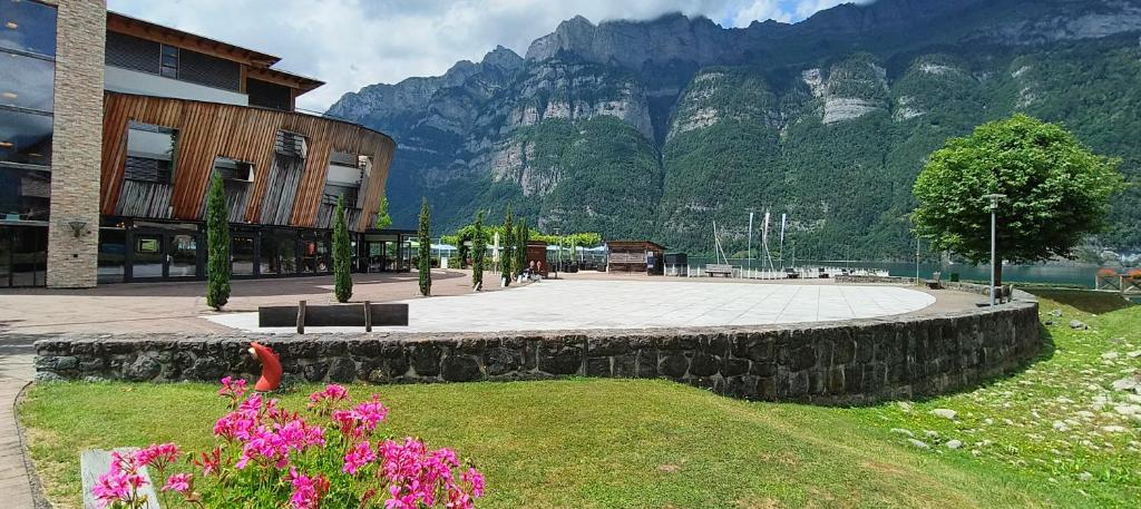 ein Gebäude mit Bergen im Hintergrund mit Blumen in der Unterkunft Marina Walensee Hotel in Unterterzen