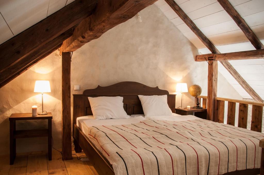 a bedroom with a bed with two lamps on tables at Transylvania Guesthouses in Cincşor