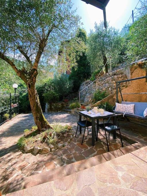 a table and chairs next to a tree on a patio at Fonzi’s House in La Spezia