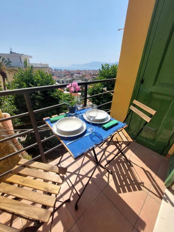 a table and chairs on a balcony with a table and plates at Il 55 dei Bastioni in Bordighera
