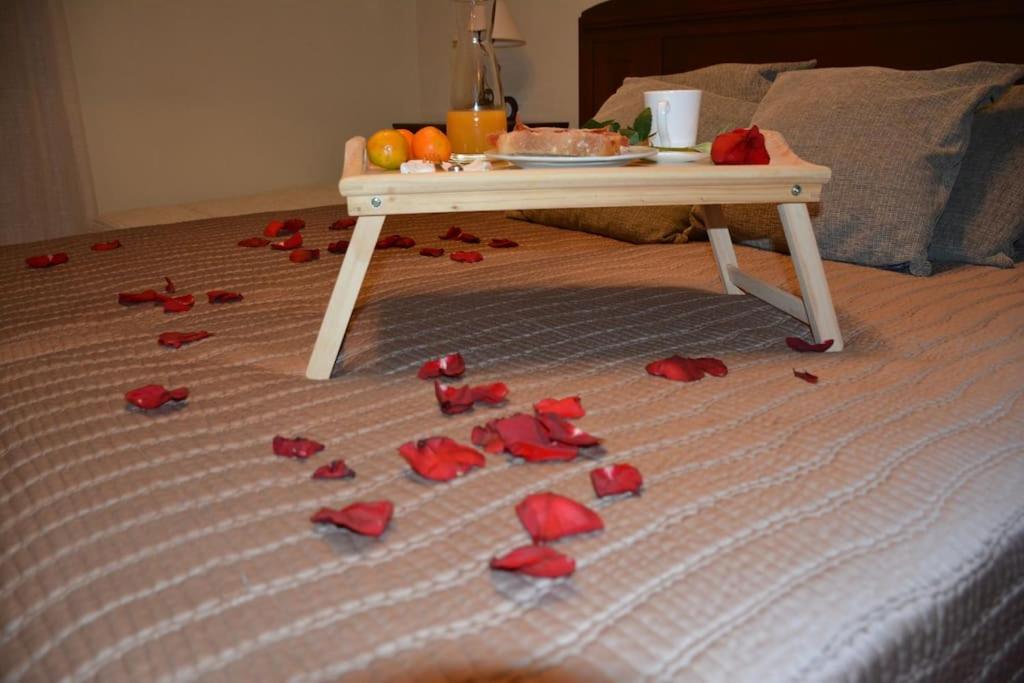 een tafel op een bed met rode rozen op de vloer bij Casa Arcadio in Villar de Canes