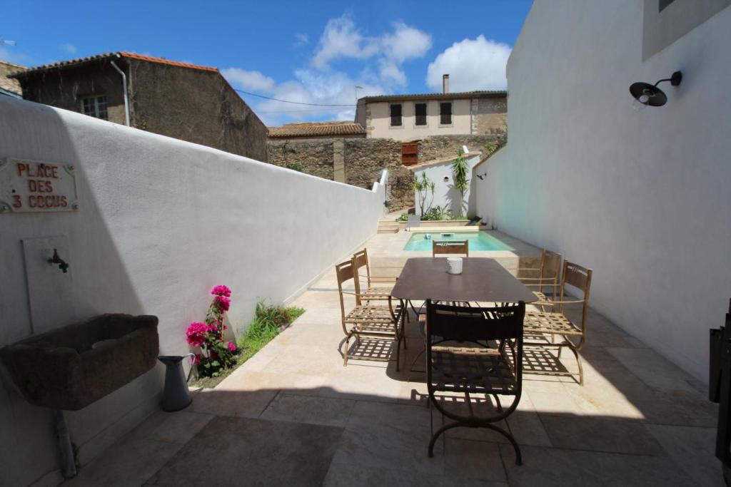 a patio with a table and chairs next to a pool at Gite sur la Founintrouze in Fabrezan