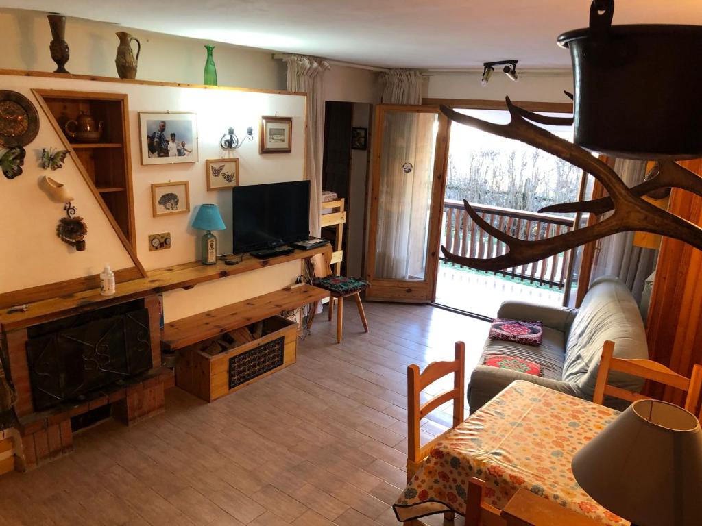 a living room with a fireplace and a television at appartamento incantevole con camino in Rocca di Mezzo