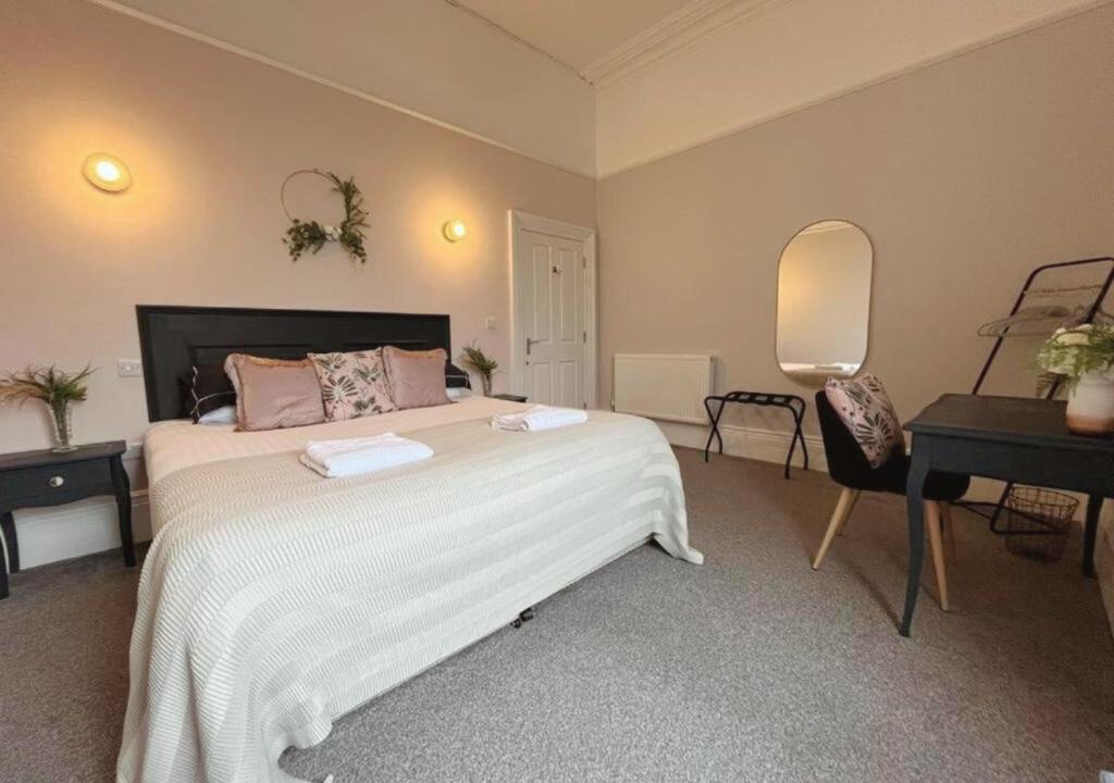 sypialnia z dużym białym łóżkiem i lustrem w obiekcie 3 Sheets To The Wind, Boutique Holiday Apartment in Torquay w mieście Torquay