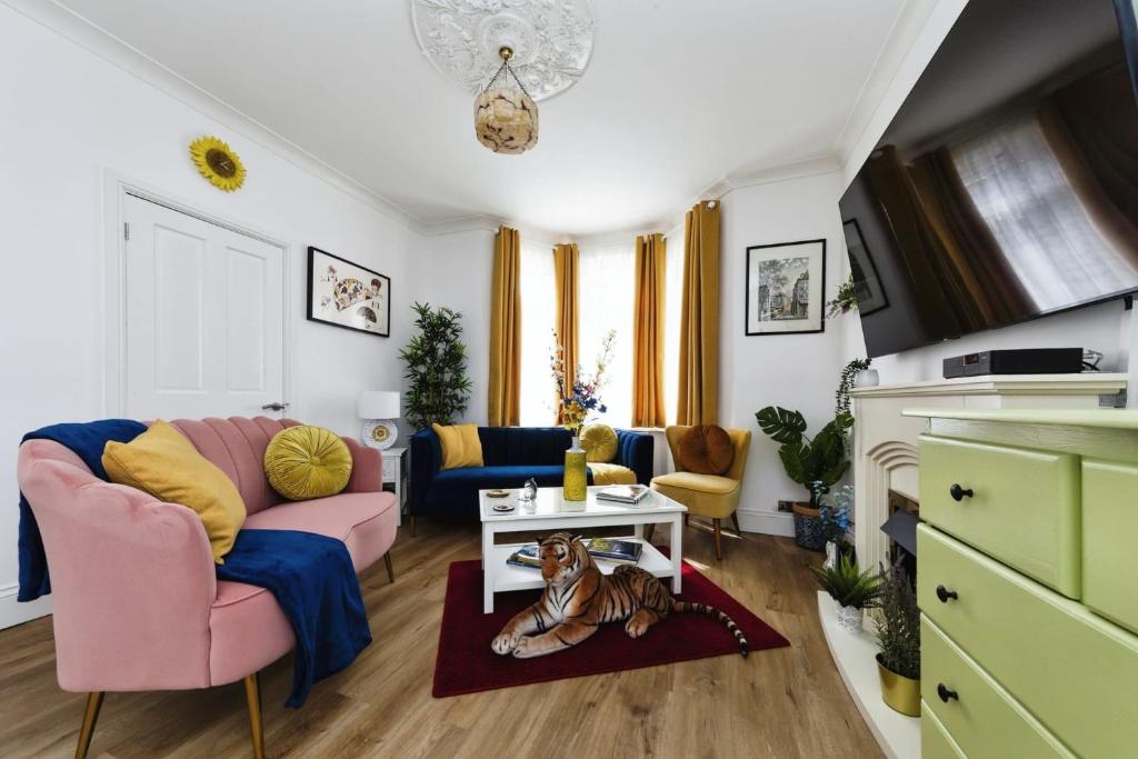 een woonkamer met een bank en een hond op een tapijt bij Your Chic 3BR Home Comfort and Style in London in Londen