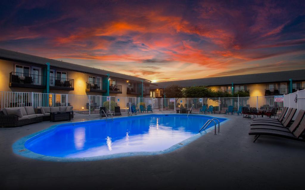 a large swimming pool in a hotel with a sunset at Hotel Elev8 Flagstaff I-40 Exit 198 Butler Ave in Flagstaff