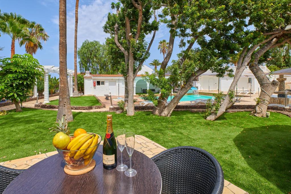 un tavolo con una ciotola di banane e una bottiglia di vino di BeExclusive apartamentos ad Adeje