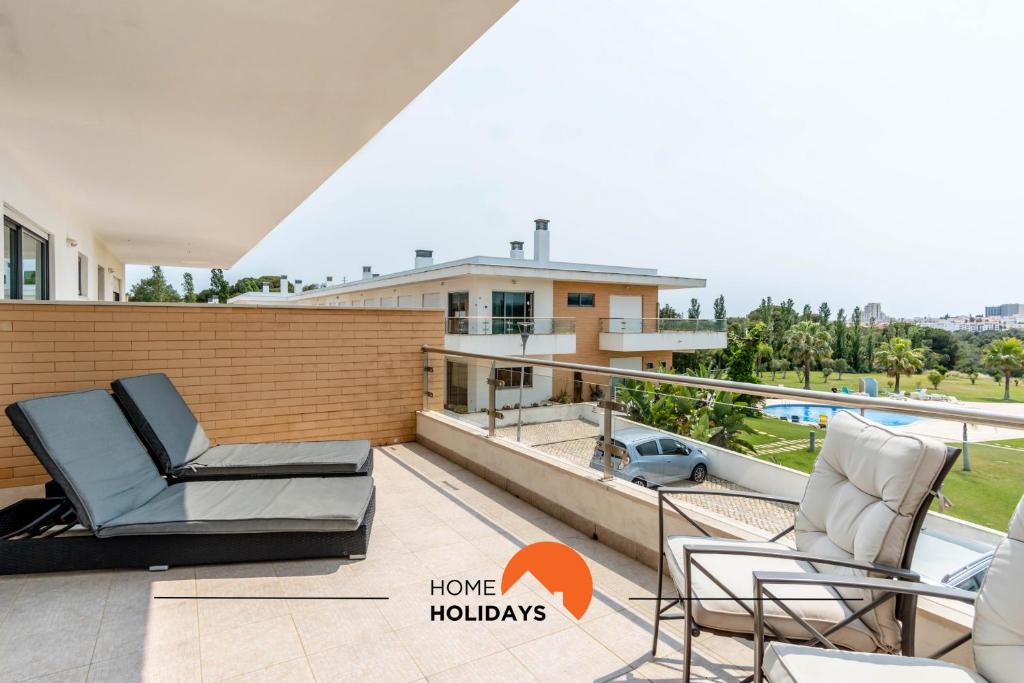 a balcony with two chairs and a view of a house at #160 V3 Vila Branca 92 by Home Holidays in Mosqueira