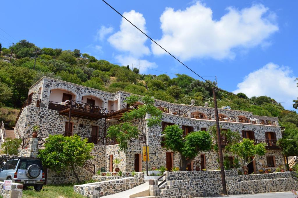 ein Steinhaus vor einem Berg in der Unterkunft Romantzo in Mandrákion