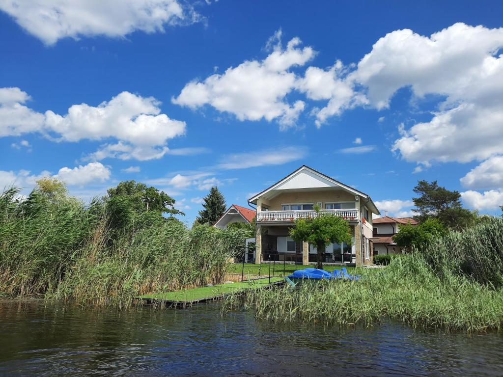 una casa seduta sul fianco di un fiume di Sunny Beach Villa a Szántód
