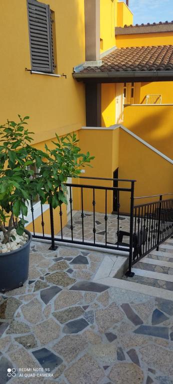 a black railing in front of a yellow building at Apartments Sandra in Vrsar