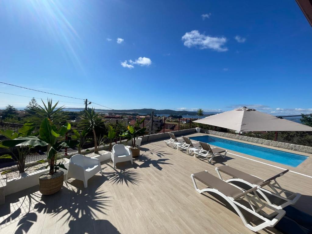 une villa avec une piscine et des chaises longues dans l'établissement VILLA CON VISTAS AL MAR, à Sanxenxo