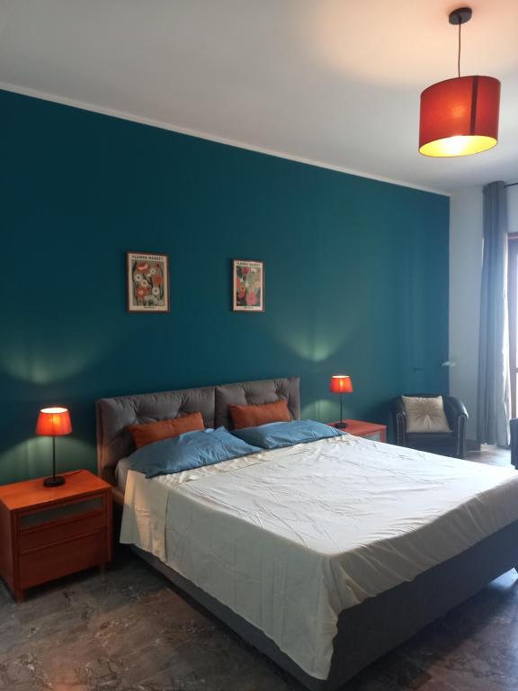una camera con un grande letto con una parete blu di Le Stanze di Bimba a Terni