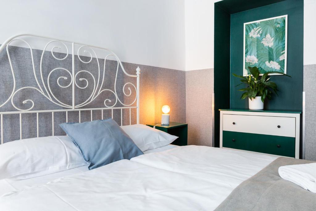 1 dormitorio con cama blanca y cabecero grande en Friendhouse Apartments Starovislna, en Cracovia