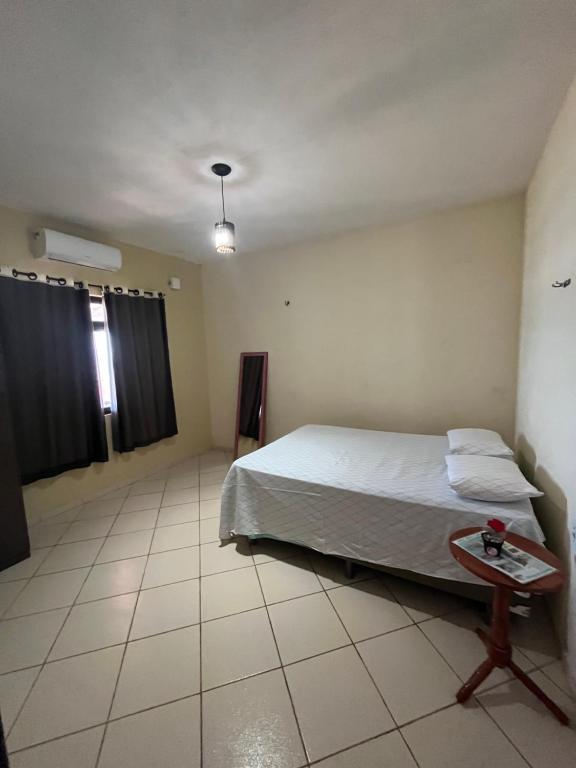 - une chambre avec un lit et une table dans l'établissement Hospedagem da Cleidiane, à Icapuí
