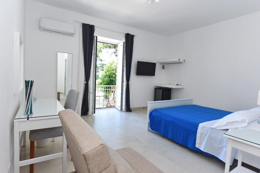 1 dormitorio con cama, escritorio y ventana en Addore Re Mare en Santa Maria di Castellabate
