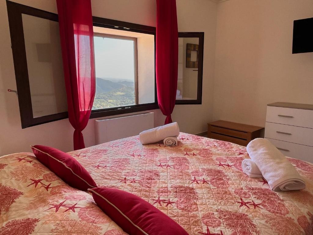 a bedroom with a bed with red curtains and a window at Le Sorgenti Guest House in Ilbono