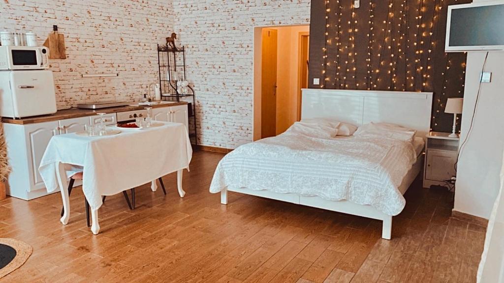 a bedroom with a bed and a table and a kitchen at Bohemian in Šamorín