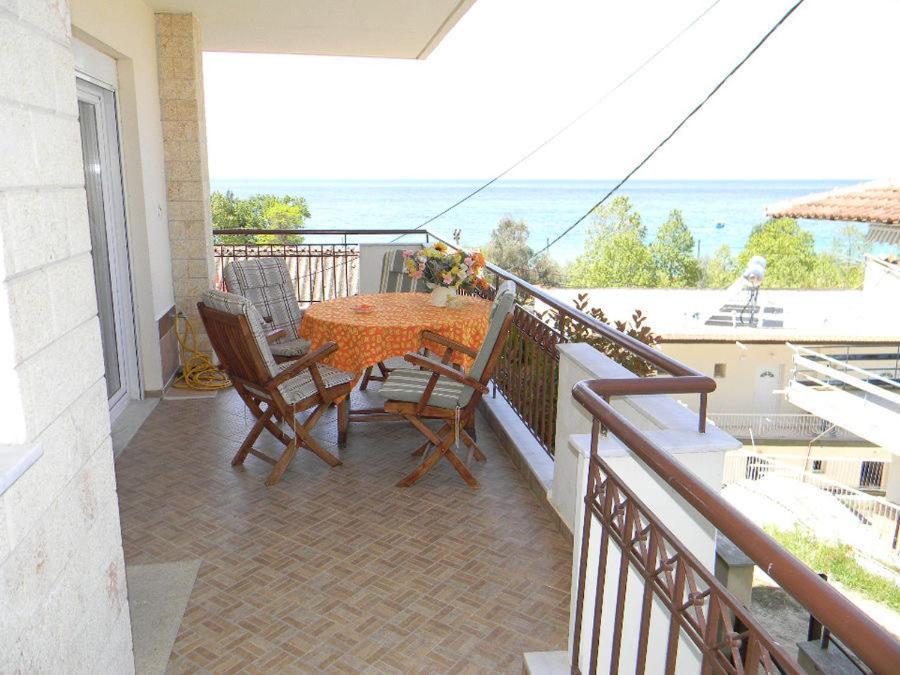 a balcony with a table and chairs and the ocean at Beach View Siviri in Siviri