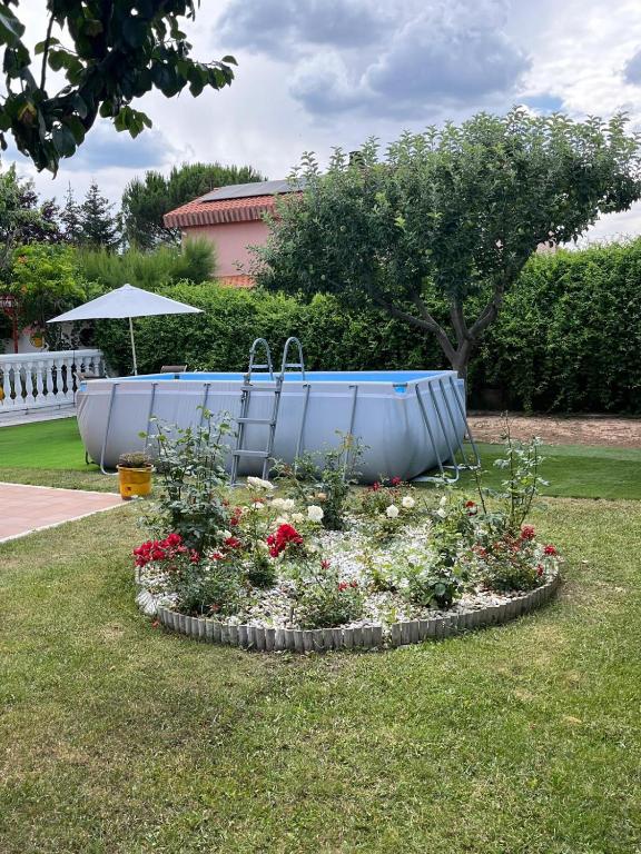 a flower bed in a garden with a large tub at Cuencaloft Casa Rural Cañada Molina in Arcas