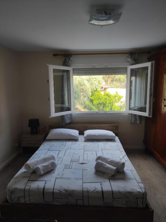 a bedroom with a large bed with a large window at Traditional villa Palio in Paleo Tsifliki