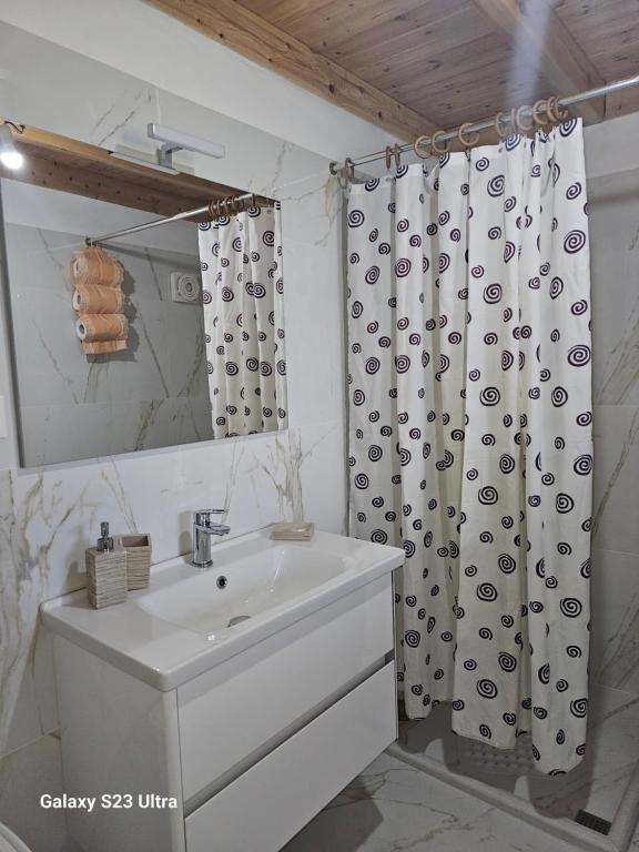 uma casa de banho com um lavatório e uma cortina de chuveiro em Xhumba Guesthouse 