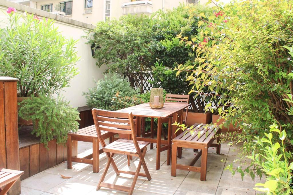 Une table et des chaises en bois sont disponibles sur la terrasse. dans l'établissement Spacious cocoon 2 steps from the Eiffel Tower, à Paris