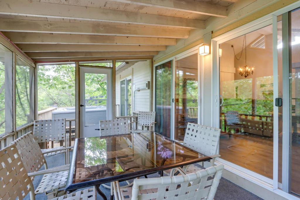 a screened porch with a glass table and chairs at Fire Pit and Pool Access Margaritaville Home! in Osage Beach