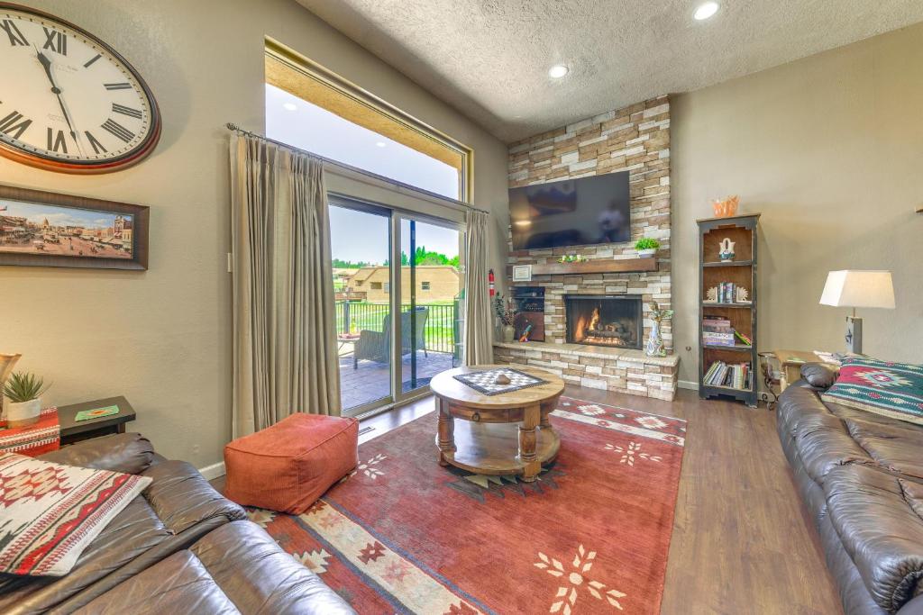 a living room with a couch and a clock at Ruidoso Golf Condo - Patio, Fire Pit and Mtn View! in Ruidoso