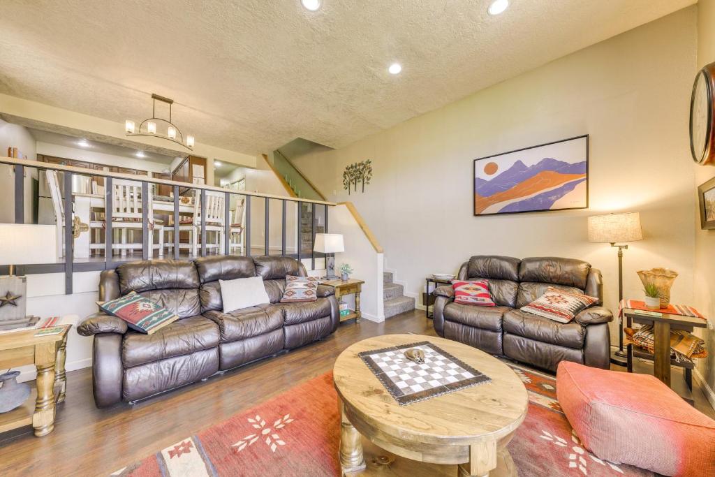 a living room with leather couches and a table at Ruidoso Golf Condo - Patio, Fire Pit and Mtn View! in Ruidoso