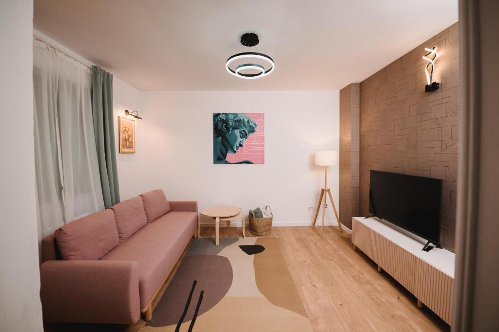 een woonkamer met een bank en een flatscreen-tv bij Cotroceni Accommodations in Boekarest