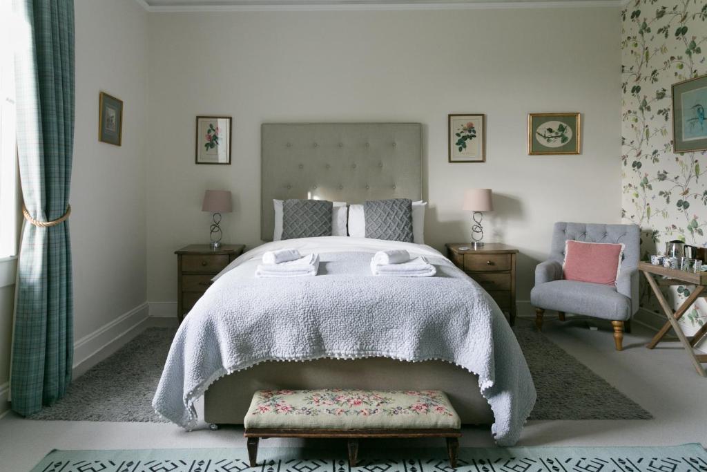 een slaapkamer met een groot bed en een stoel bij Stay On The Hill - The Coach House in Hexham