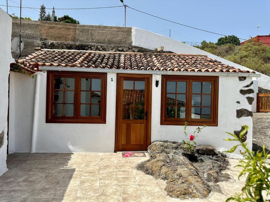 una piccola casa bianca con una porta marrone di Chozos Cottage by VV Canary Ocean Homes a Las Cruces