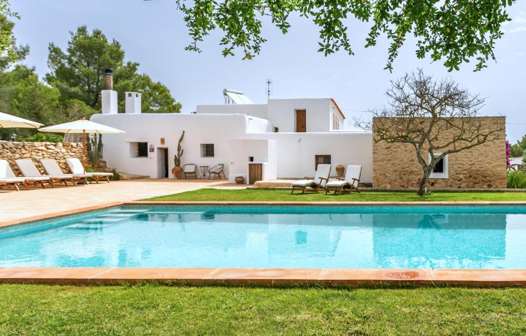 une villa avec une piscine en face d'une maison dans l'établissement CAN FERRER Authentic payesa house, à Sant Antoni de Portmany