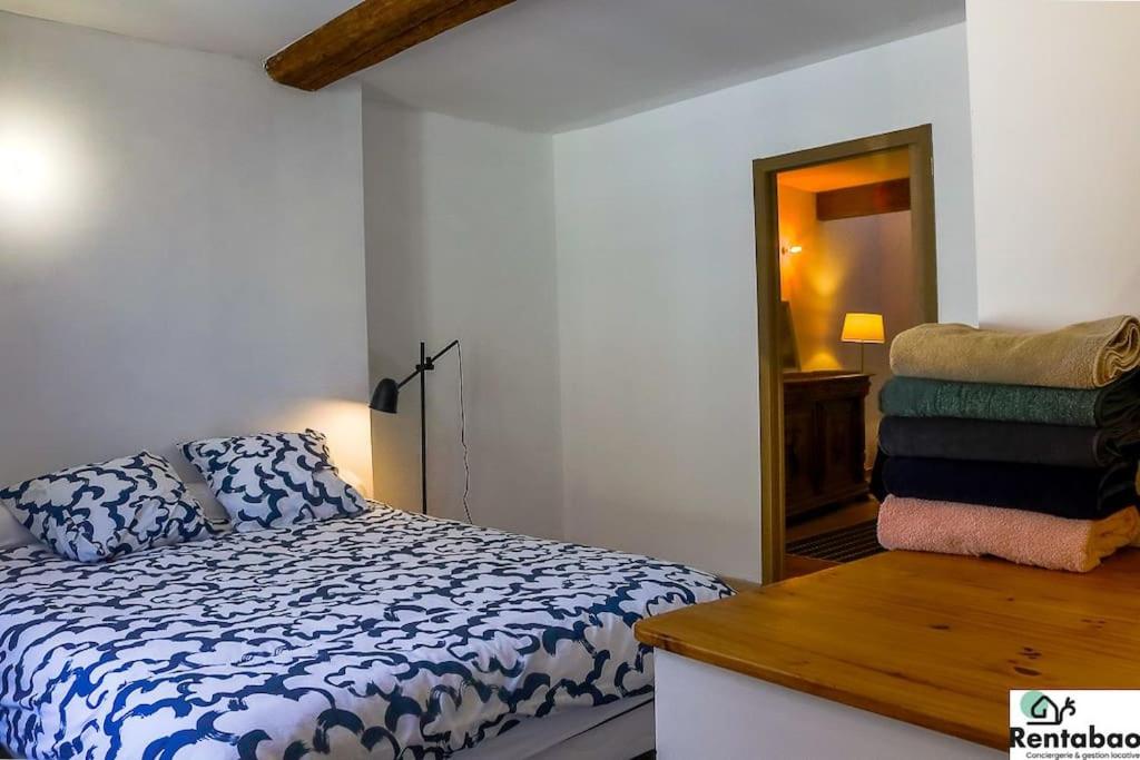 une chambre avec un lit, une table et un miroir dans l'établissement Maison de ville, à Avignon