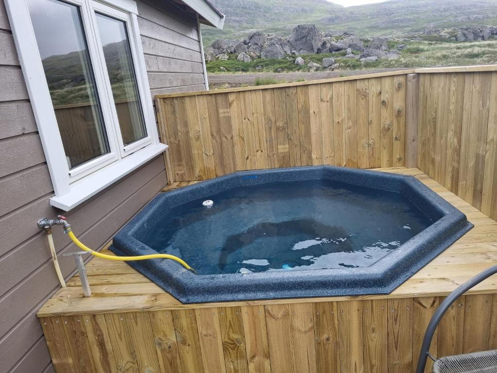Hvammur 6 with private hot tub : يوجد حوض جاكوزي على سطح المنزل.