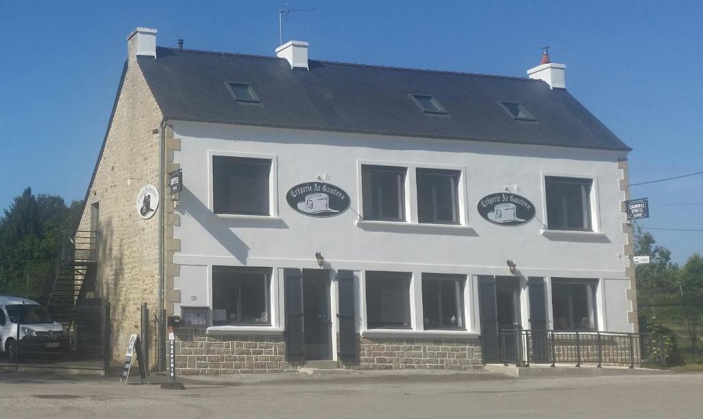 a large white house with a black roof at Ar-Gavotenn in Le Saint