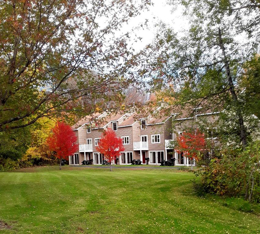 een groot huis met rode bomen ervoor bij Cathedral Ledge Resort in North Conway