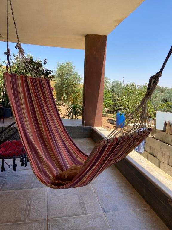 a hammock hanging in a room with a window at Simple home in Madaba