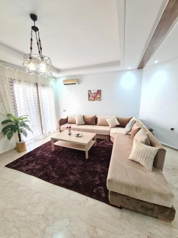 salon z kanapą i stołem w obiekcie Appartement Studio meublé à Mohammedia w mieście Al-Muhammadijja