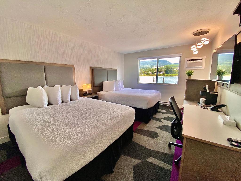 a hotel room with two beds and a desk at The Spot at Porpoise Bay in Sechelt
