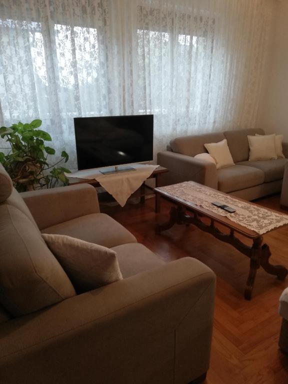 salon z kanapami, telewizorem i stołem w obiekcie Virágos Vendégház Balatonfüred w Balatonfüred