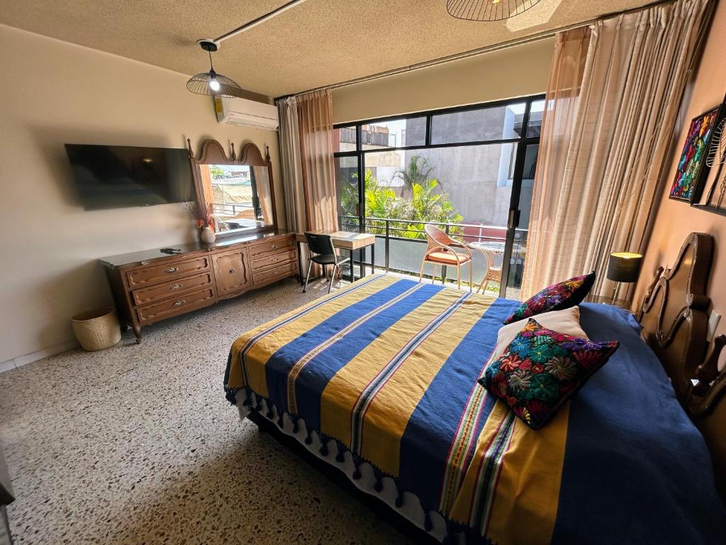 een slaapkamer met een bed en een groot raam bij Casa de las Palmas Guest House in Oaxaca City