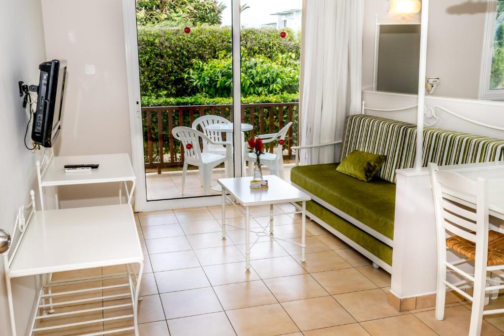 a living room with a couch and a balcony at Aktea Beach Village in Ayia Napa
