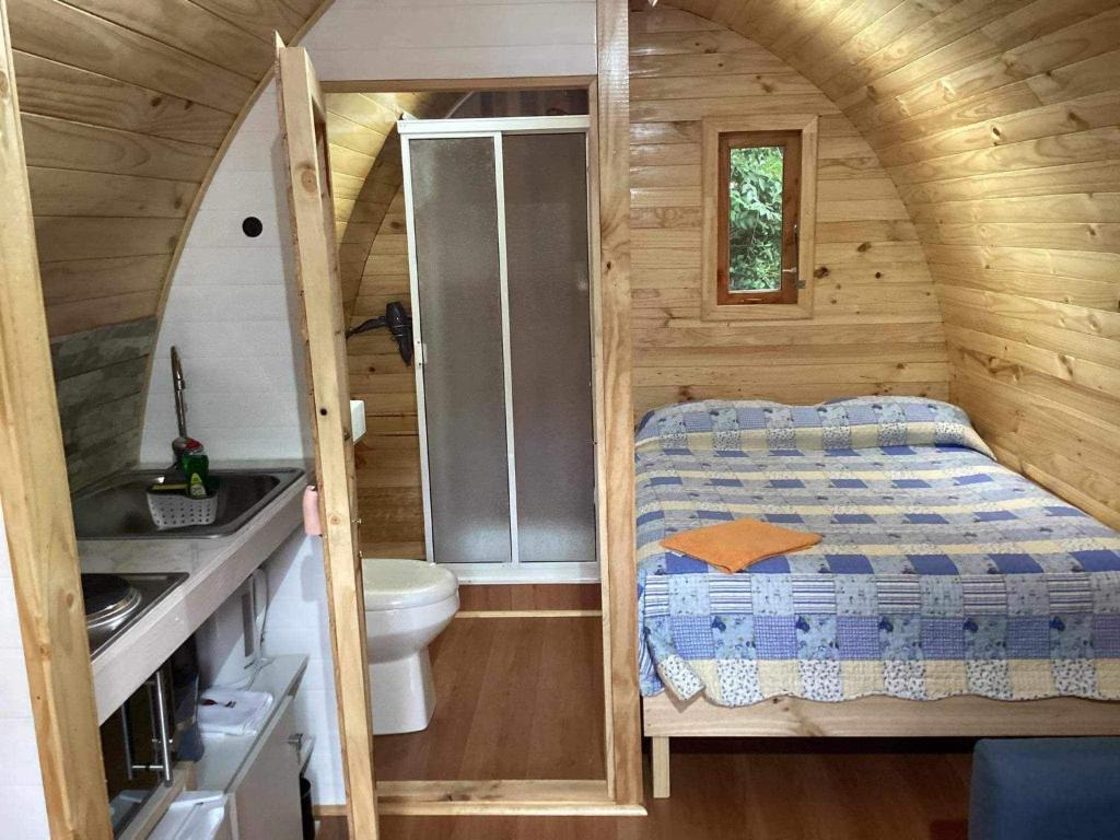 Habitación pequeña con cama y baño. en Cabañas Amatista Neltume, en Neltume