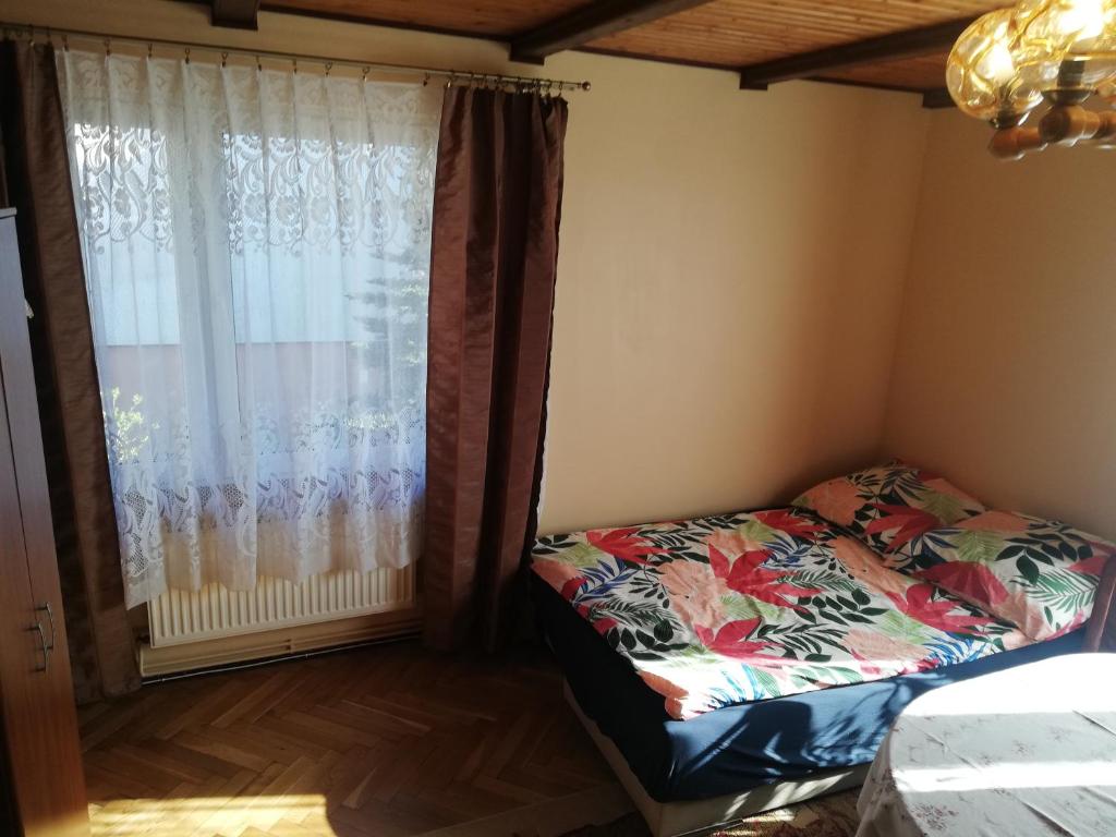 a small bedroom with a bed and a window at U Kiki in Wisełka