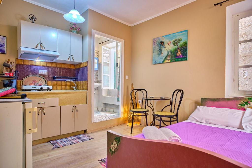 1 dormitorio con 1 cama y cocina con mesa en Helena Sweet Nest Corfu en Agios Rokkos