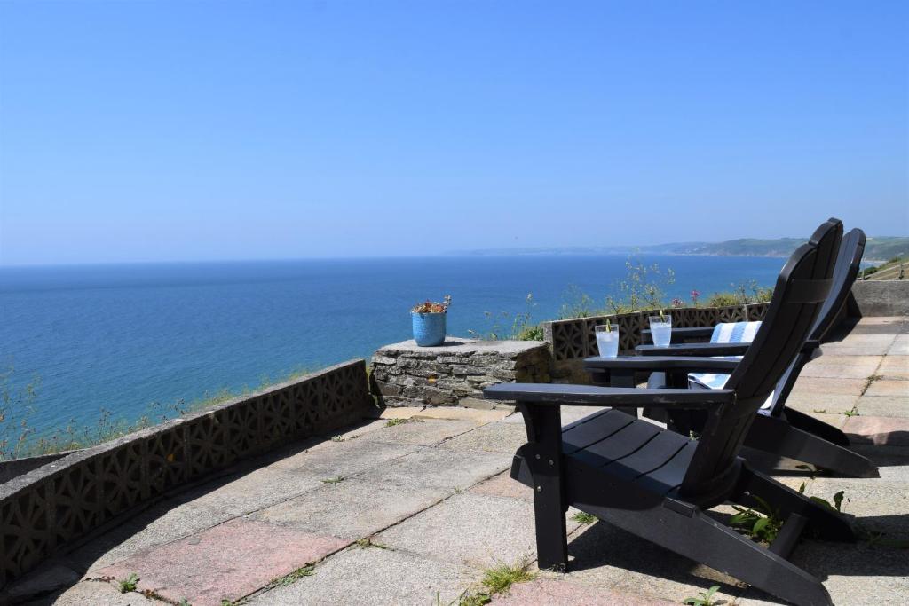 a table and chairs sitting on a patio overlooking the ocean at Westcroft 6 Withnoe Terrace in Torpoint