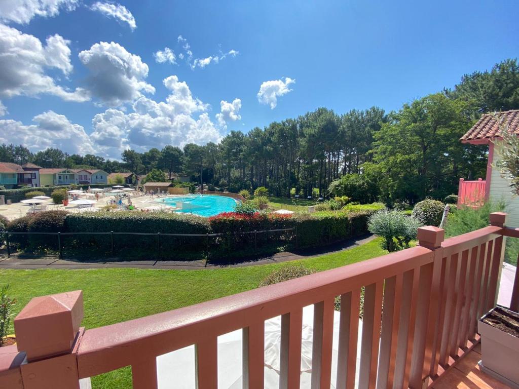 une vue sur une piscine depuis le balcon d'une cour dans l'établissement Maison à Lacanau Océan classée 2 étoiles, à Lacanau-Océan